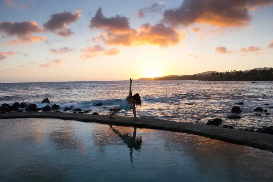 A yoga pose by the sea at sunset